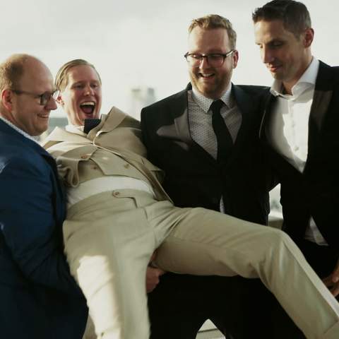 Dennis wordt lachend opgetild door zijn vrienden op de SS Rotterdam